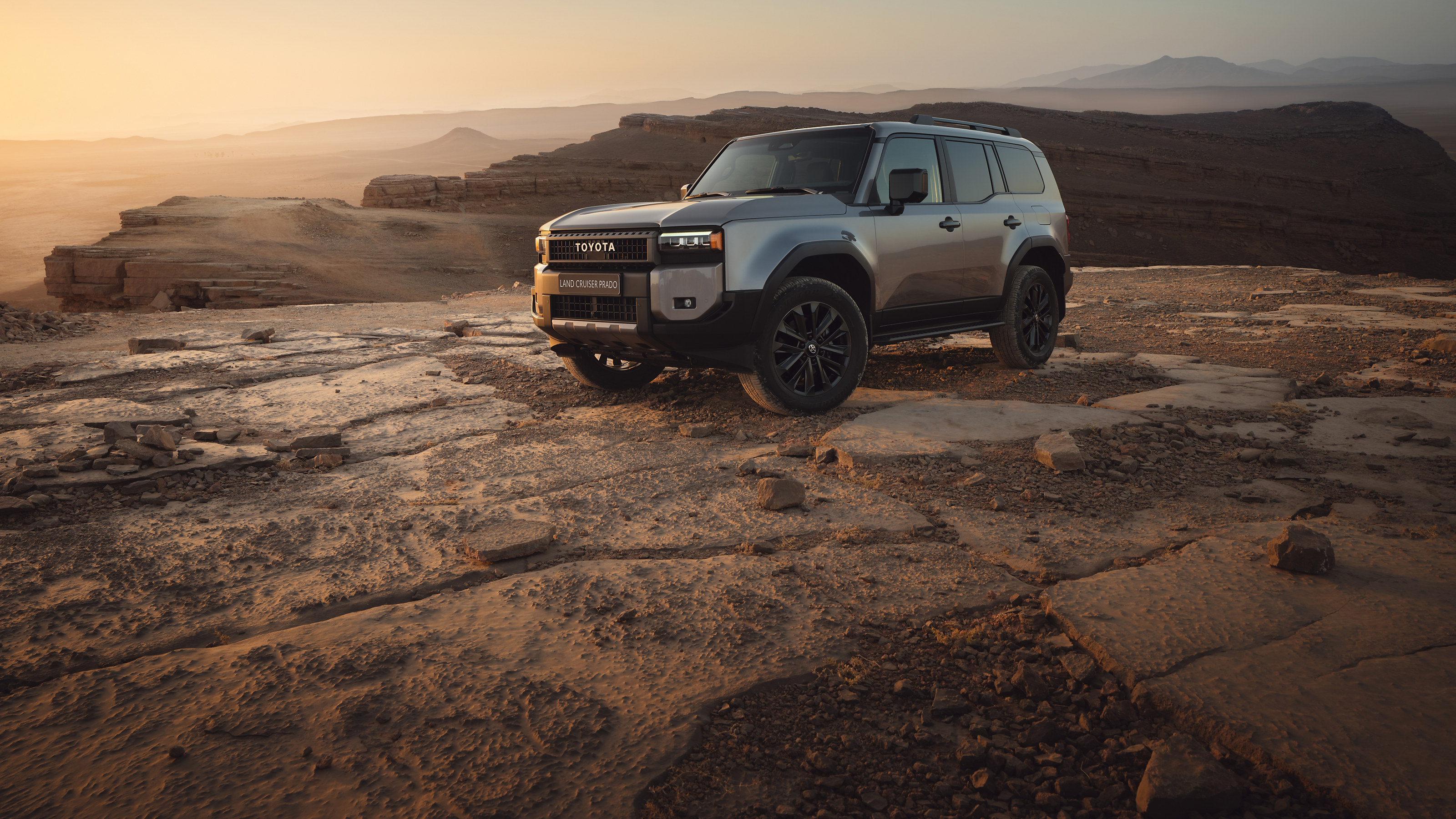 A Land Cruiser with hood defelctor and wind deflectors parked in the desert.