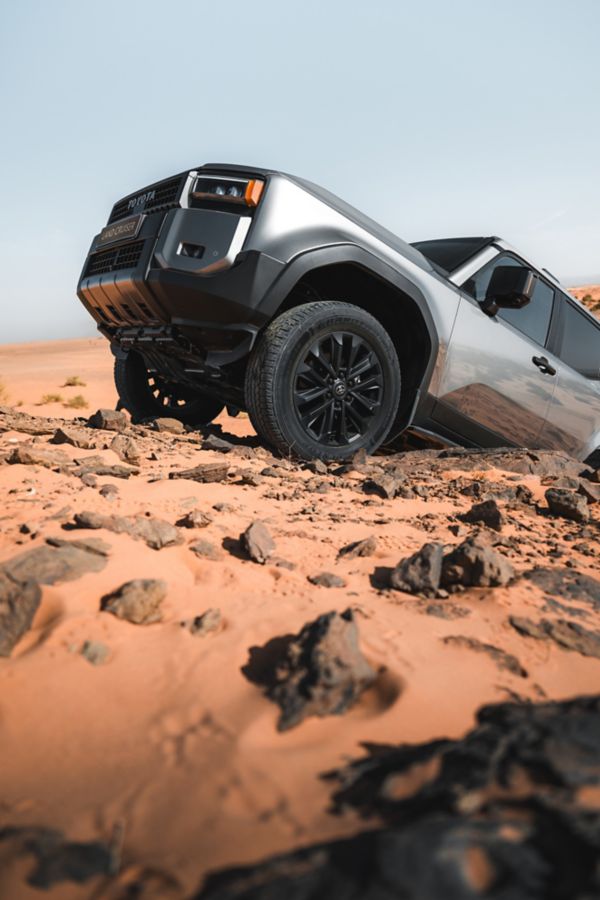 Silberner Land Cruiser erklimmt einen Hügel mit extremer Steigung.