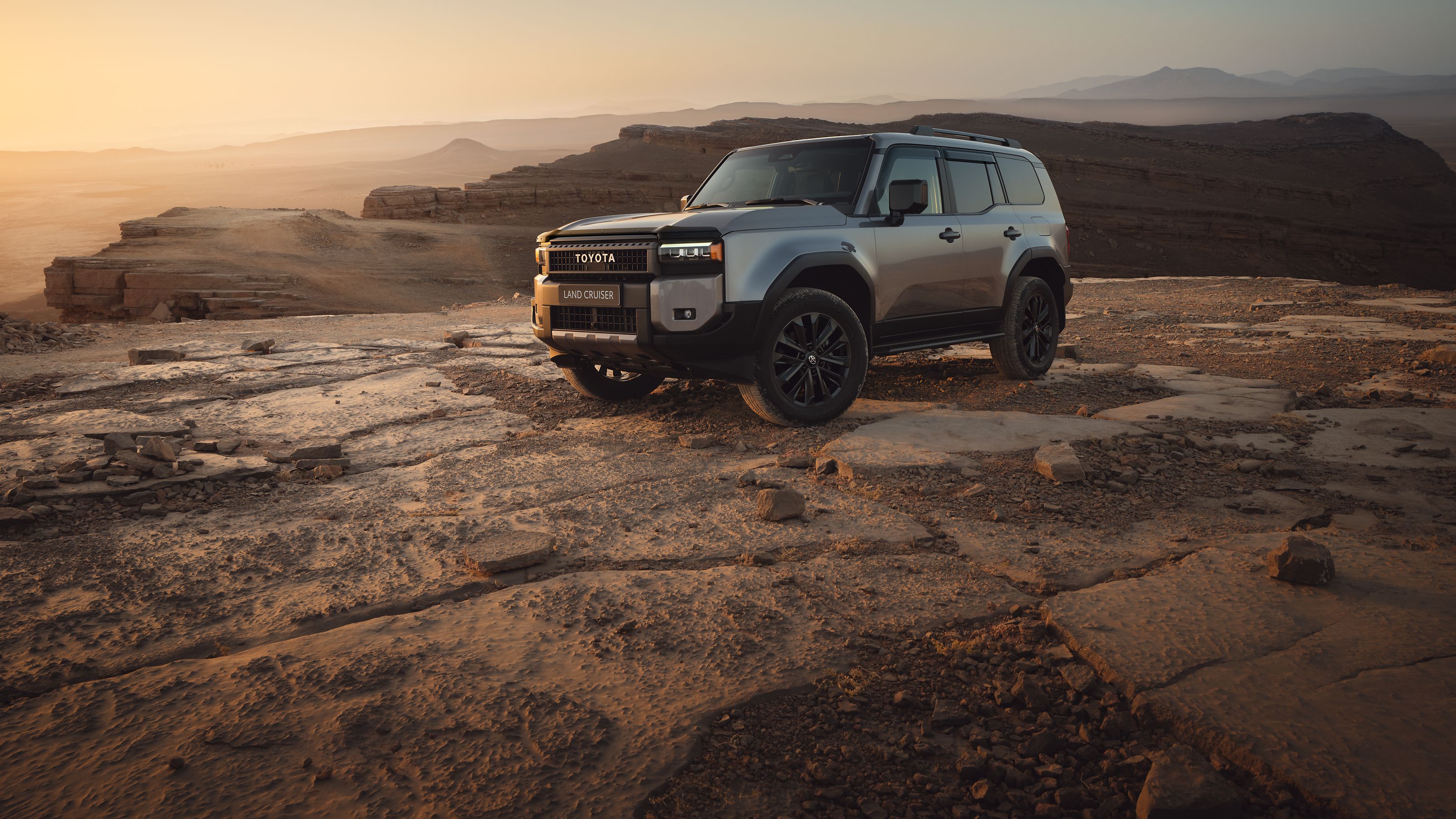 A Land Cruiser with hood defelctor and wind deflectors parked in the desert.