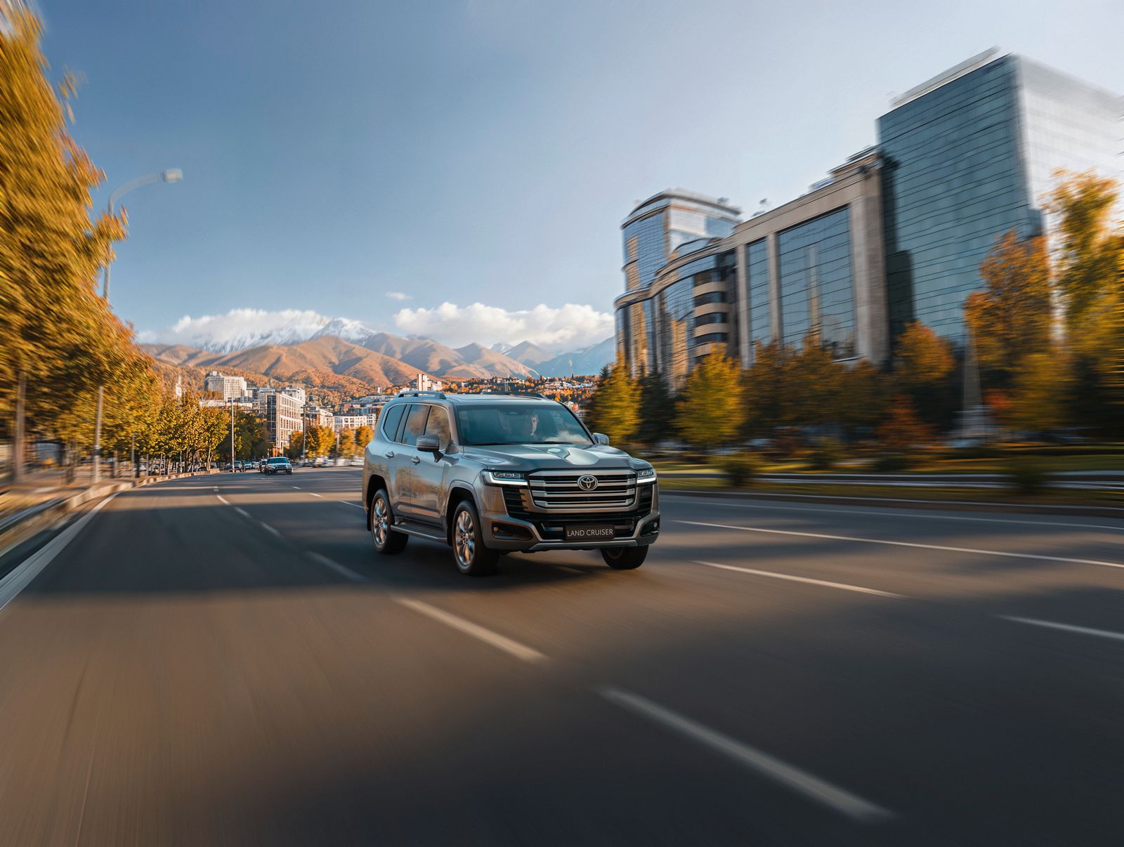 Land Cruiser 300 glides through a modern city boulevard.