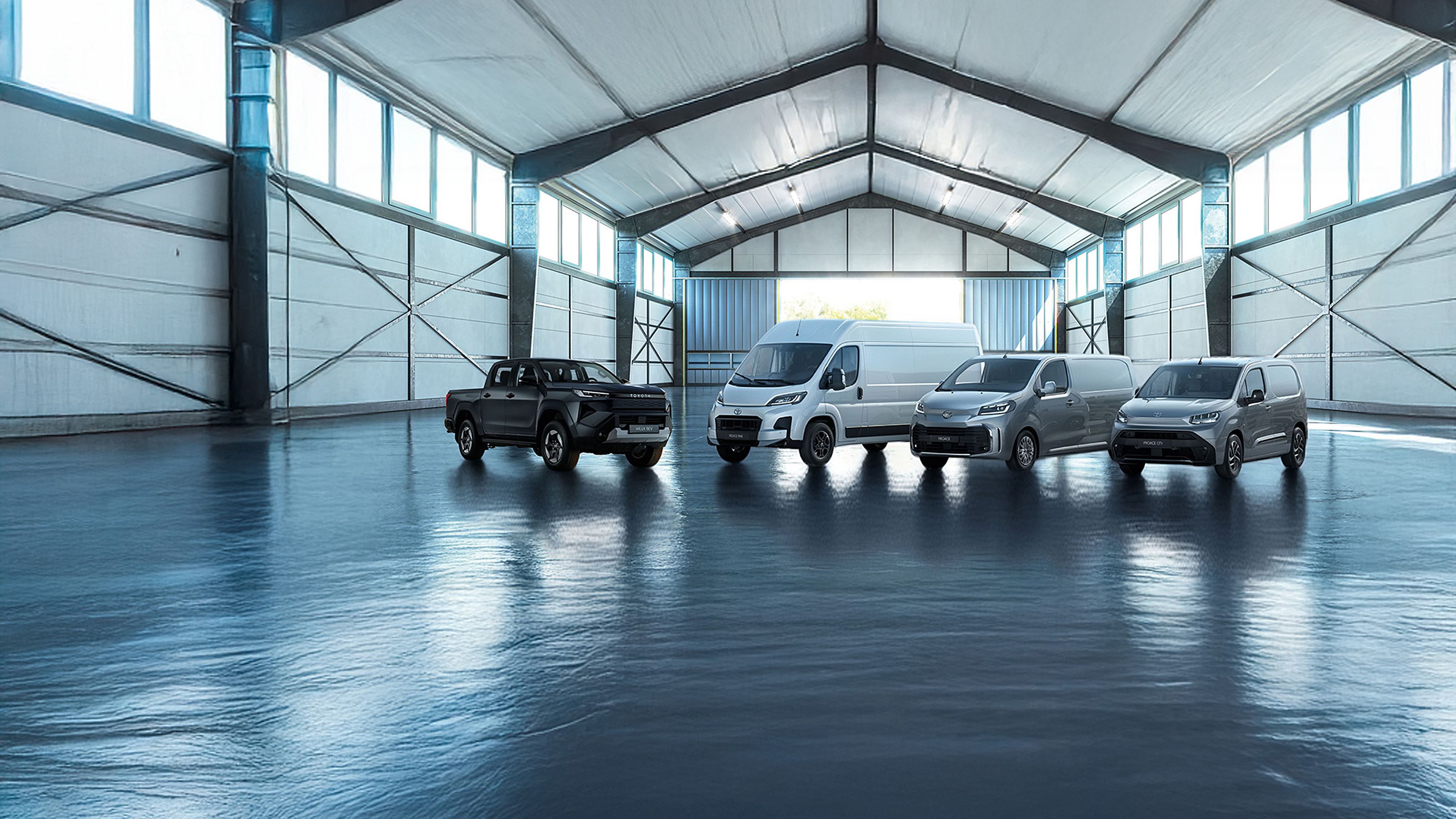 Quatres camionnettes Toyota garés dans un entrepôt.