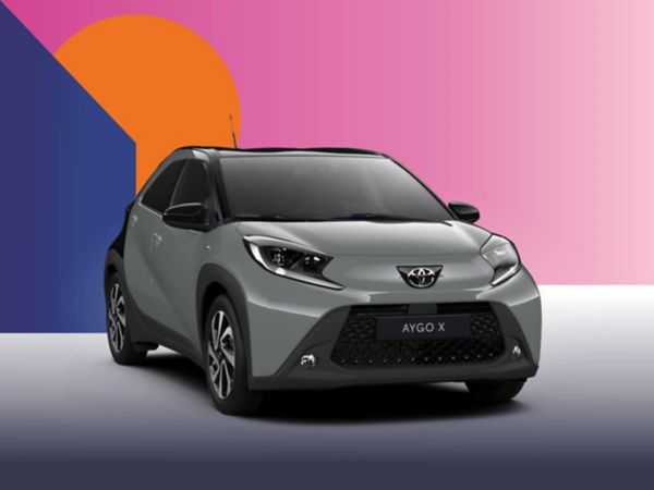 Ein khaki Toyota Aygo X Teamplayer auf einem bunten Hintergrund.