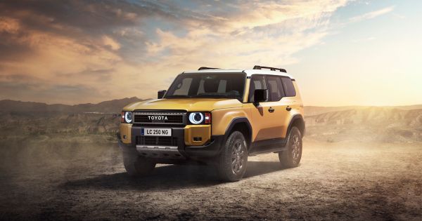 Ein gelber Toyota Land Cruiser steht diagonal zur Kamera in einer Wüste.