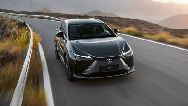 A man leaning against a parked Lexus