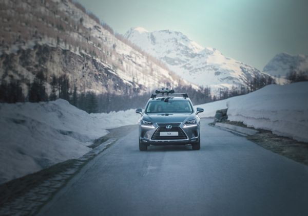 A Lexus RX with a roof rack driving through a city