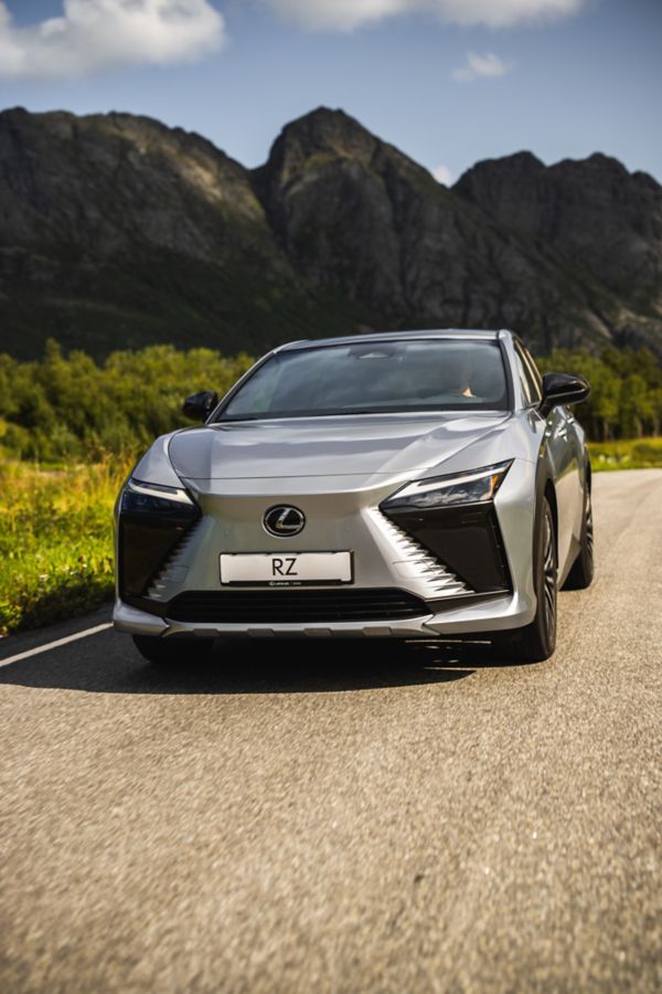 A Lexus RZ driving on a road in the mountains