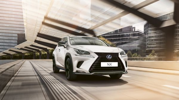 A white Lexus NX driving in the city