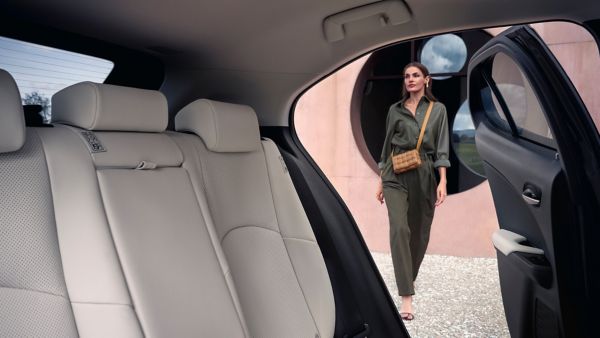 Ein Blick aus dem Innenraum eines Lexus auf den eine Frau zuläuft