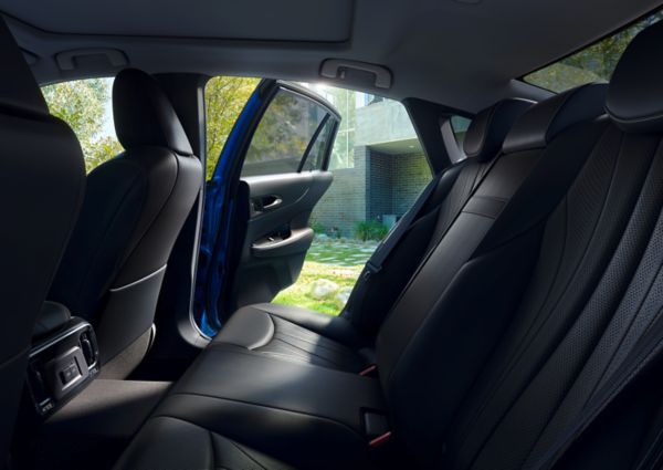 Rear passenger view of the Mirai with the door open, the car is parked in front of a house.