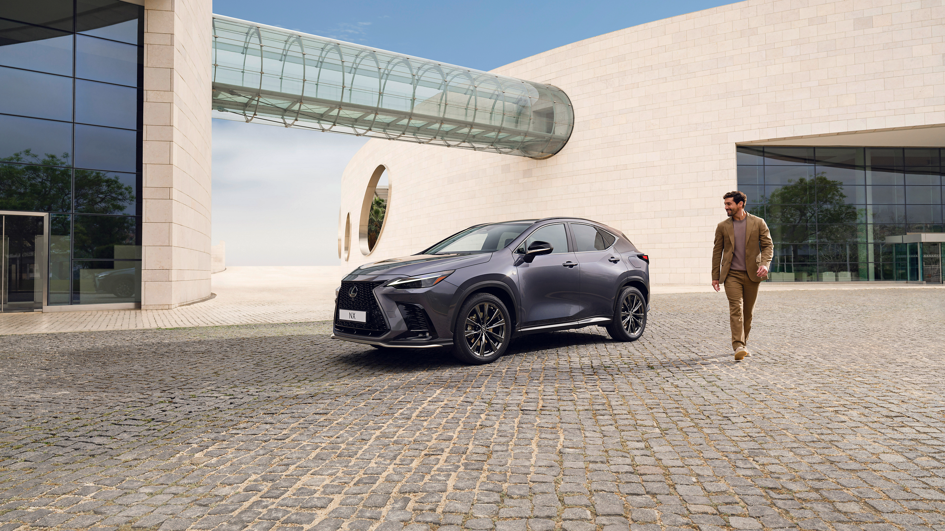 A person walking past a parked Lexus NX