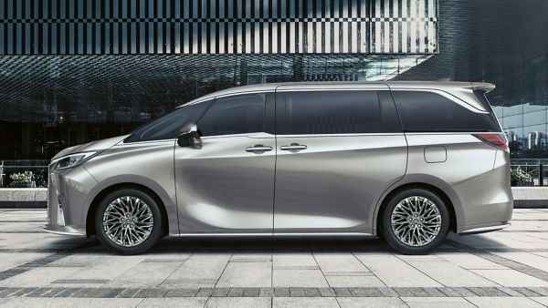 Seitenansicht eines silbernen Lexus LM geparkt vor einem modernen Gebäude