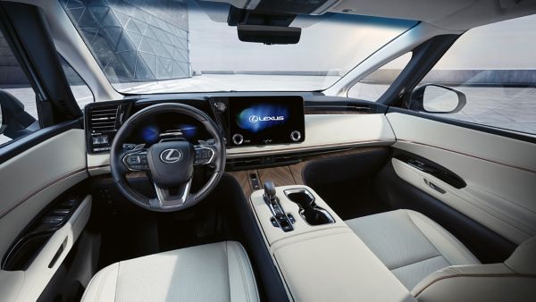 Der Innenraum eines Lexus-Fahrzeugs mit modernem Armaturenbrett, Touchscreen-Display und luxuriösen Ledersitzen. 