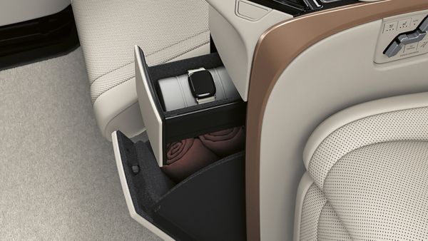 Staufach im Innenraum des Lexus LM mit einer geöffneten Schublade, in der ein silberner Behälter und eine zusammengerollte Decke liegen.