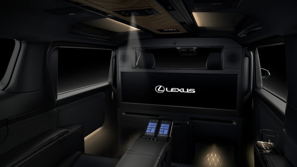 Luxuriöser Innenraum eines Lexus-Fahrzeugs mit Ambiente-Beleuchtung, einer Mittelkonsole mit Bedienelementen und einem großen Bildschirm mit dem Lexus-Logo.