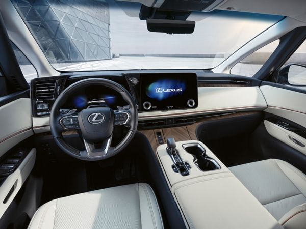 Der Innenraum eines Lexus-Fahrzeugs mit modernem Armaturenbrett, Touchscreen-Display und luxuriösen Ledersitzen. 