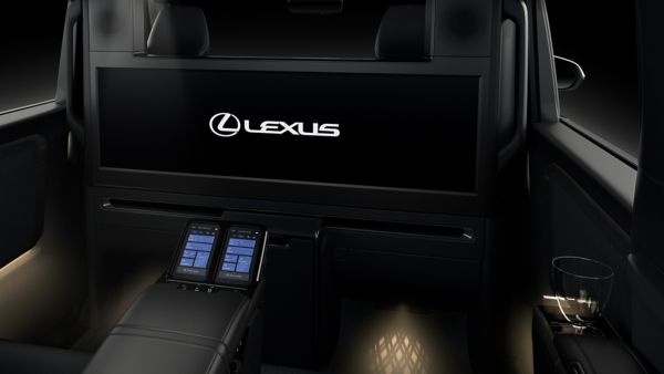 Luxuriöser Innenraum eines Lexus-Fahrzeugs mit Ambiente-Beleuchtung, einer Mittelkonsole mit Bedienelementen und einem großen Bildschirm mit dem Lexus-Logo.