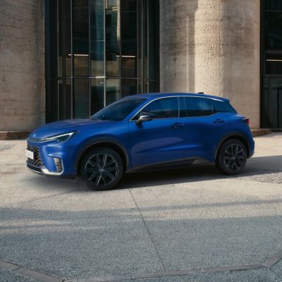 Eleganter blauer Lexus LBX, der vor einem modernen Gebäude geparkt ist