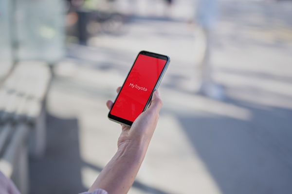 Person hält ein Smartphone in der Hand, auf dem das MyToyota Logo zu sehen ist