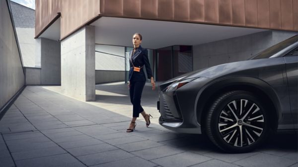 woman standing next to a Lexus