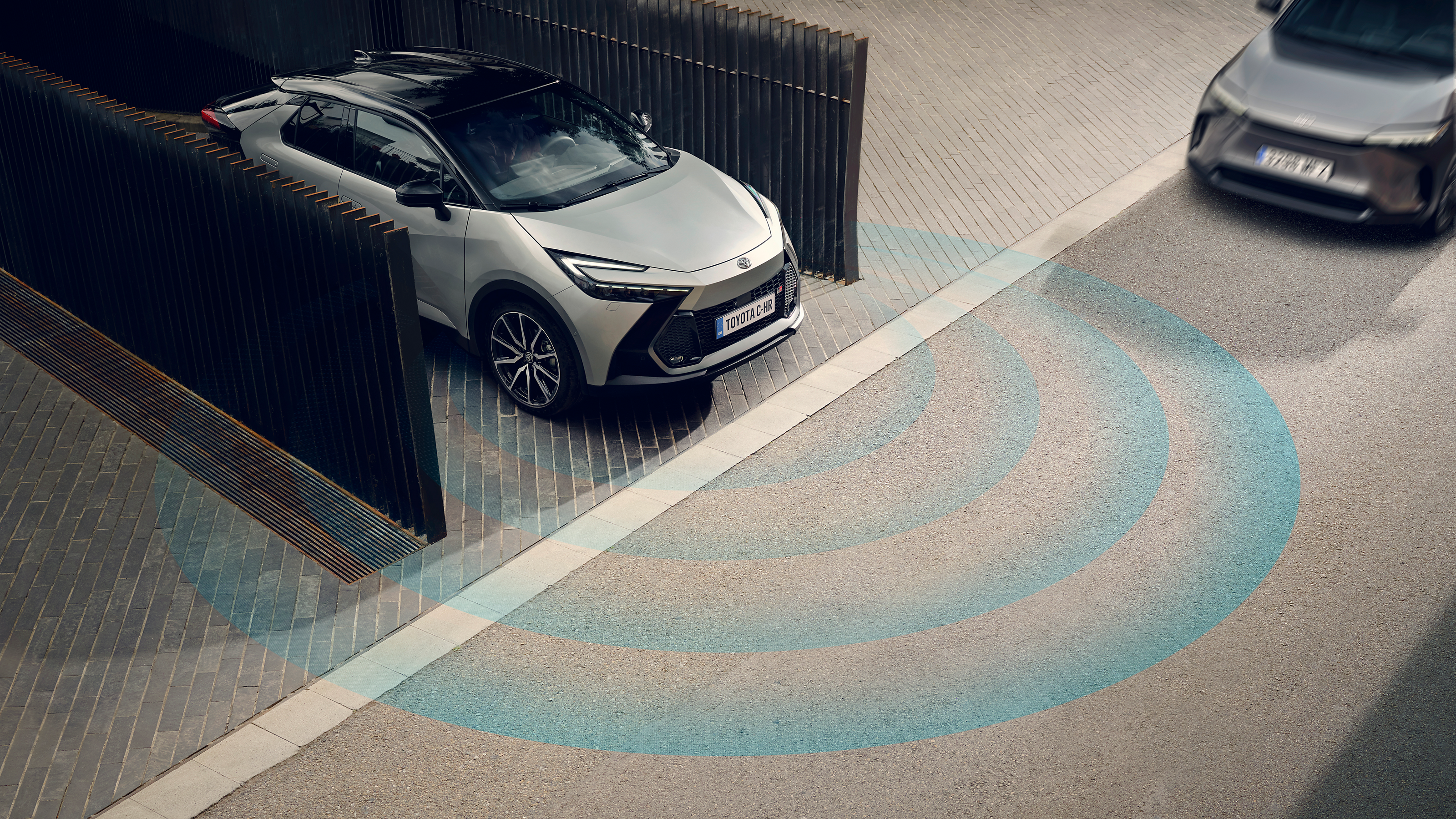 Toyota C-HR na križovatke, kde k nej prichádza iný automobil.