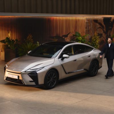 A Lexus owner approaches their vehicle ahead of a drive