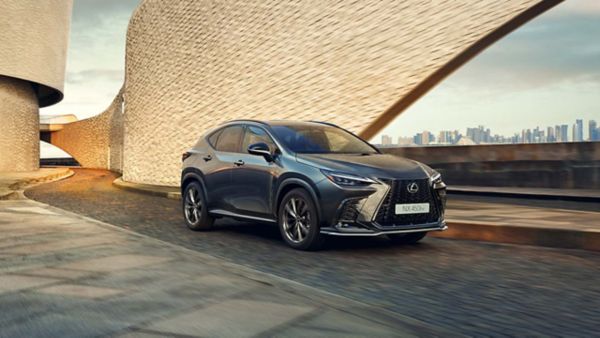 A green Lexus UX driving down a city street showcasing its sleek design.