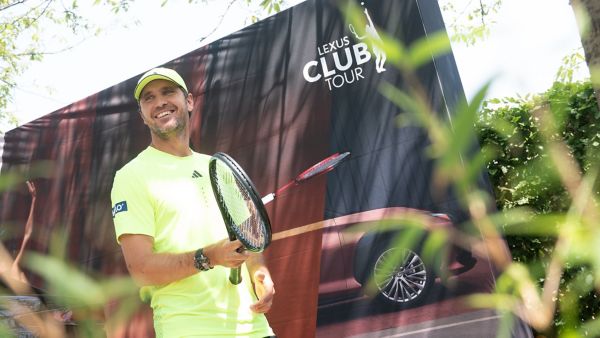 Mischa Zverev mit Tennisschläger in der Hand vor einem Lexus Banner