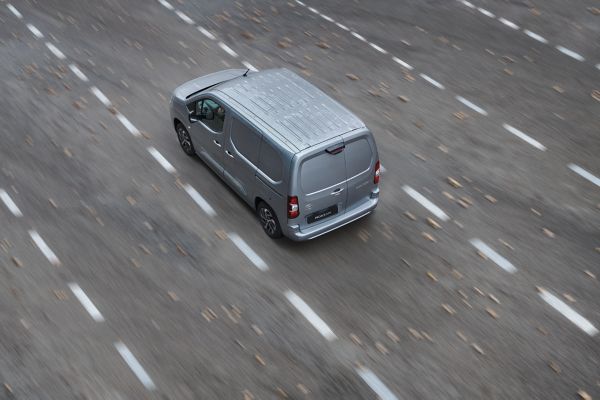 A Toyota Proace drives a long country road