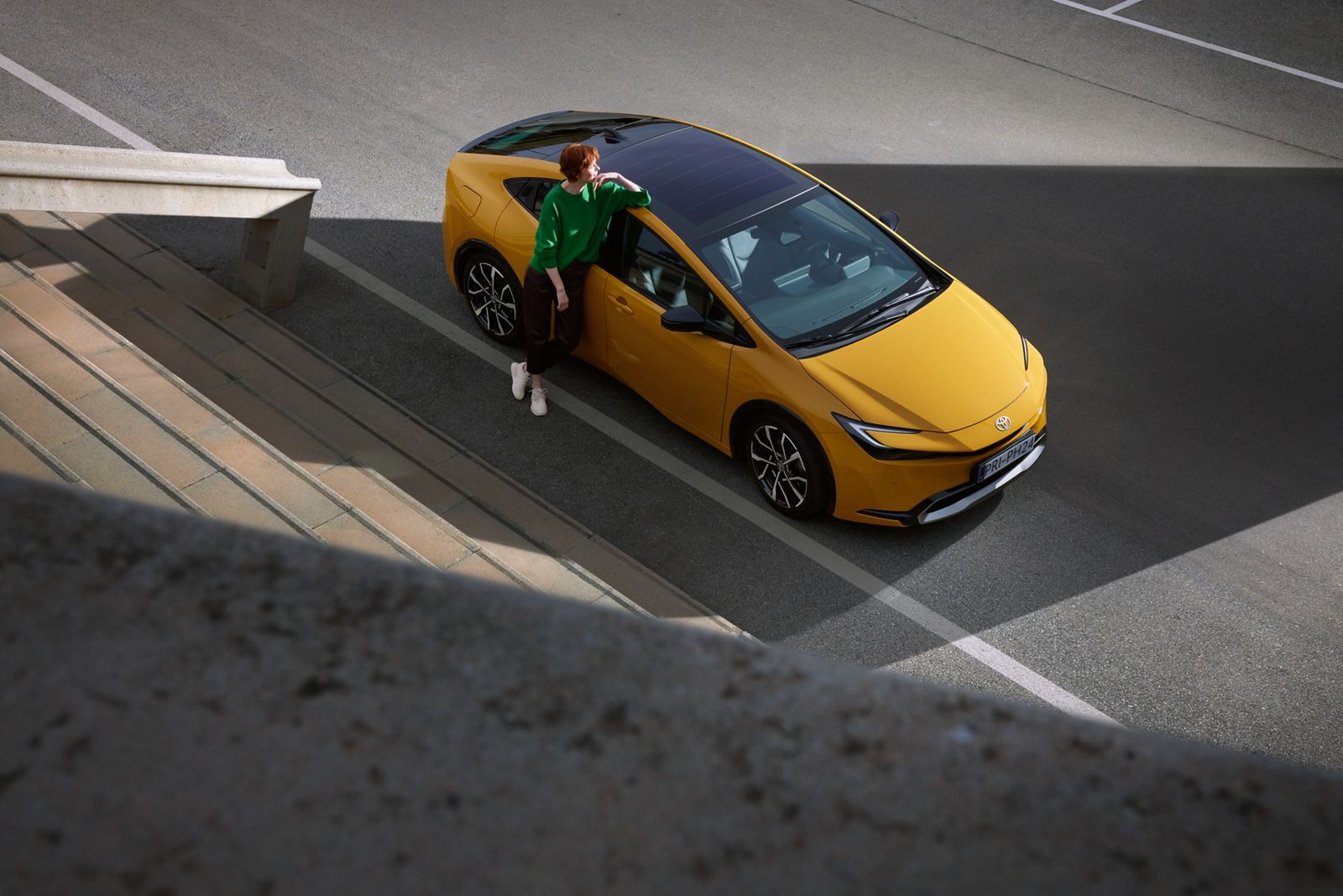 An owner relaxes with their Prius Plug-in Hybrid on the street.