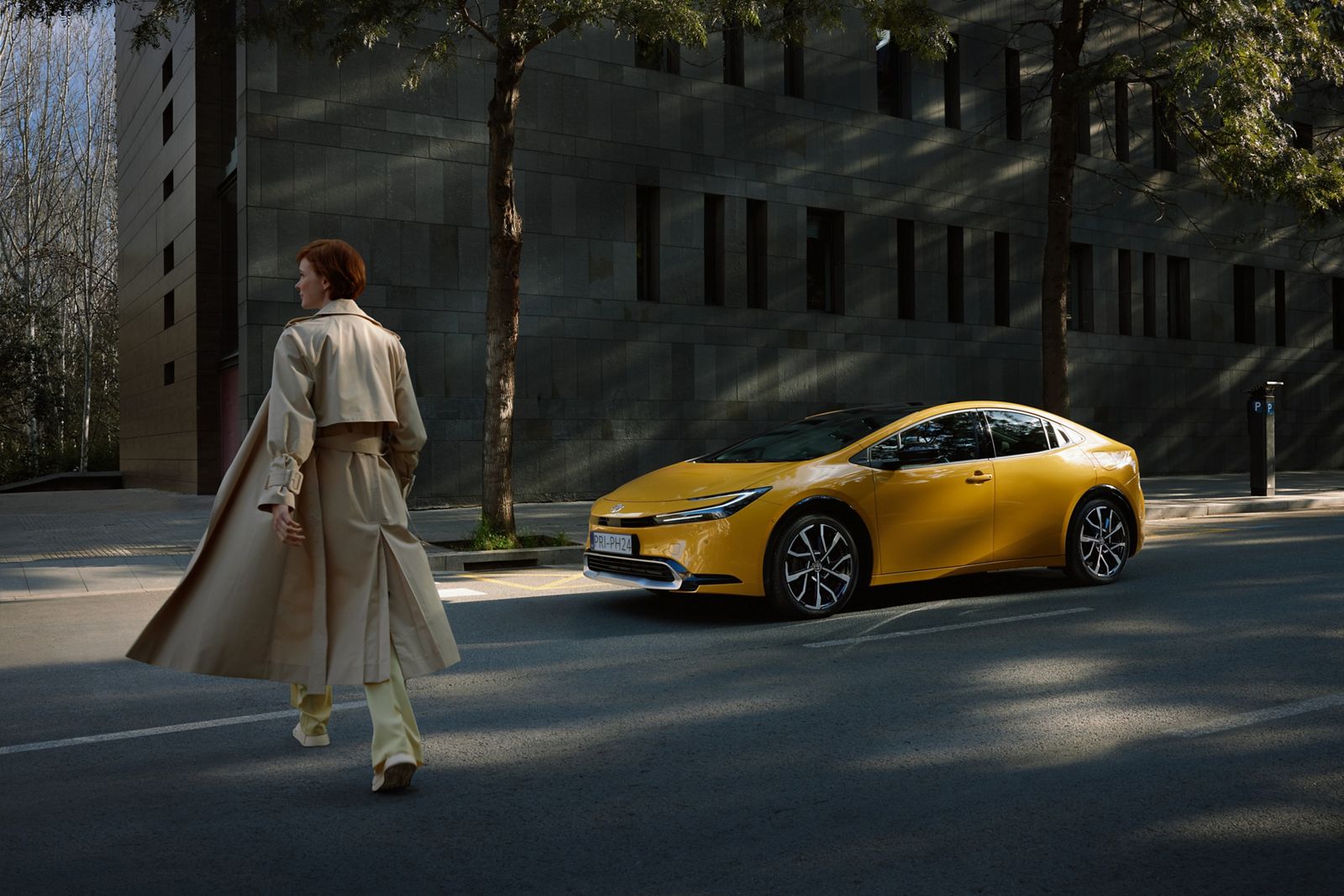 A person using a pedestrian crossing with Prius stopping before.