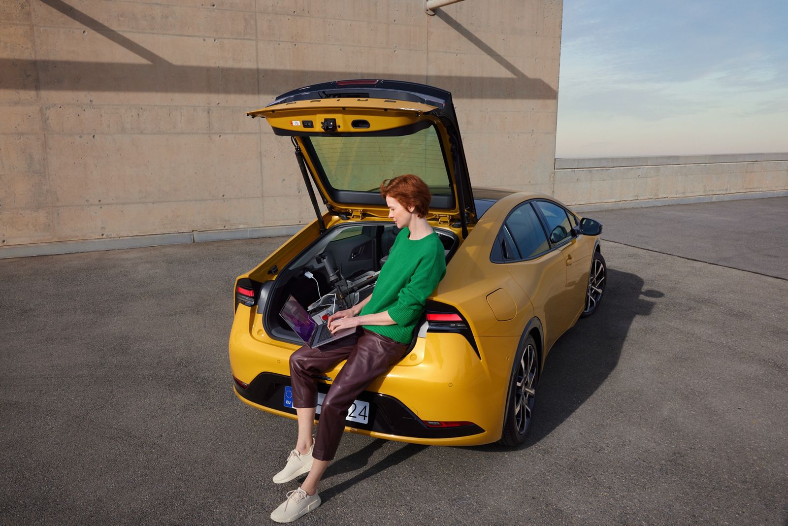 A Prius Plug-in Hybrid owner charges their laptop using the 12V charger.