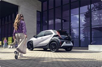 Kobieta idzie w kierunku Toyoty.