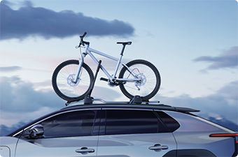 Toyota z rowerem zamontowanym na bagażniku dachowym.