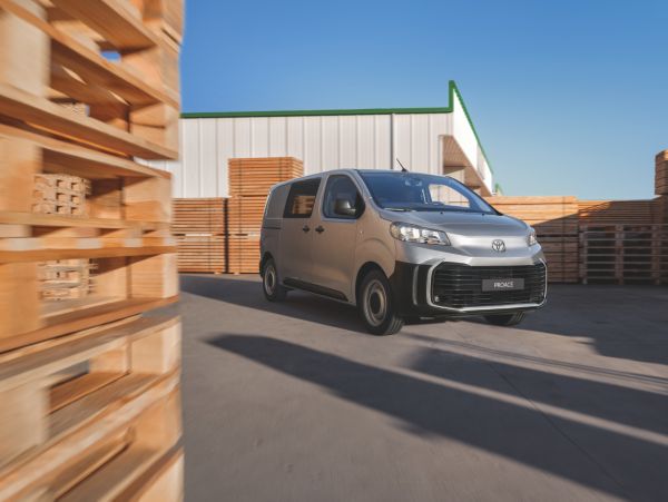Toyota Proace fährt durch ein Lager mit Holzpaletten.