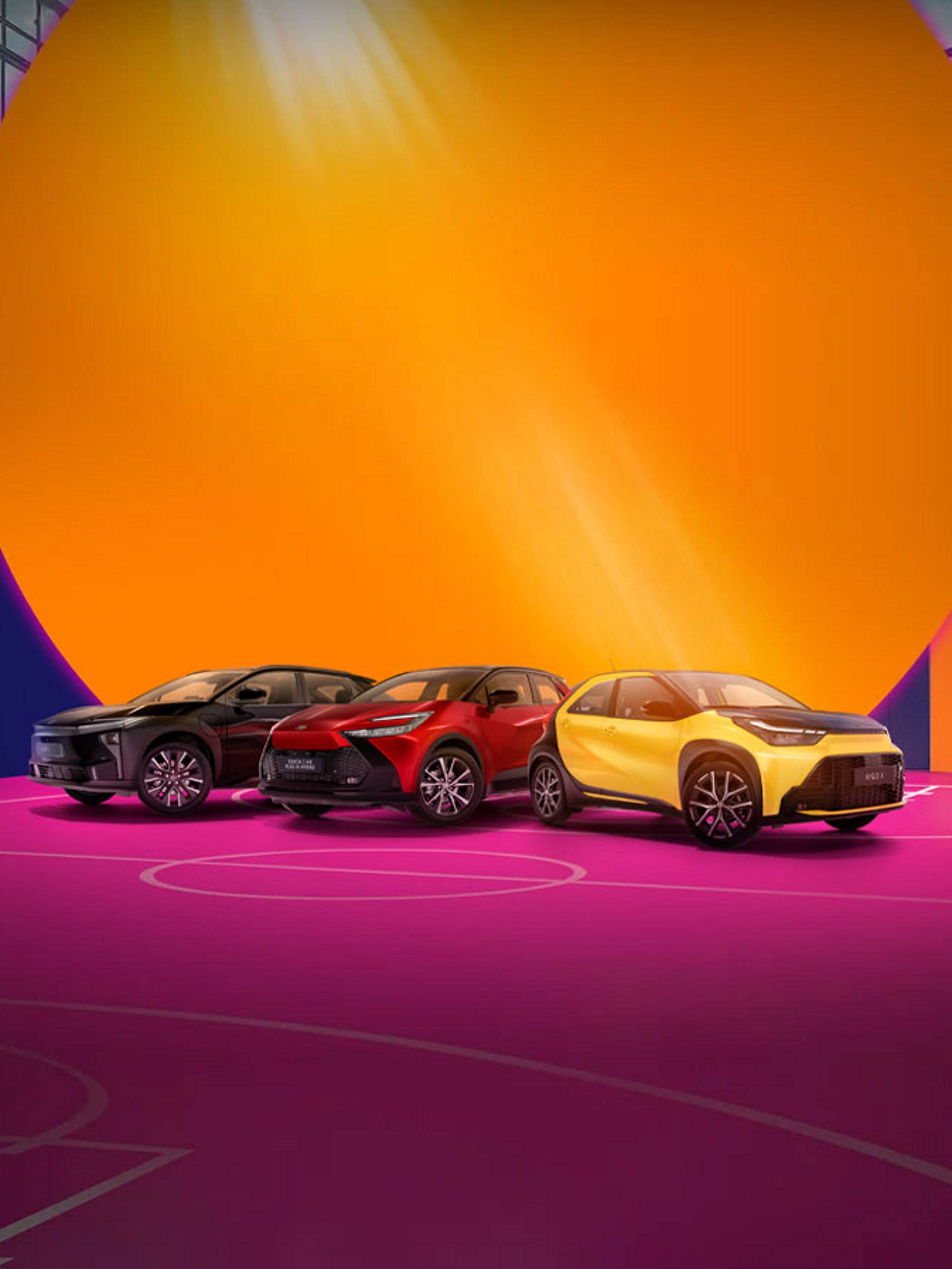 Drei Fahrzeuge von Toyota stehen auf einem pinken Basketballfeld. Die Wände sind in bunten Formen dekoriert.