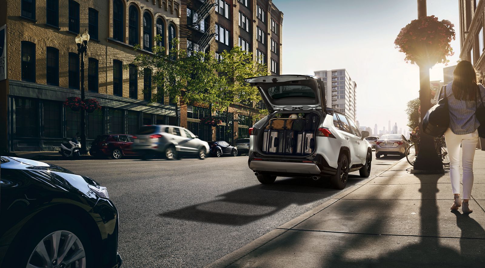 Un RAV4 dans la rue, chargé de bagages avant un départ en voyage