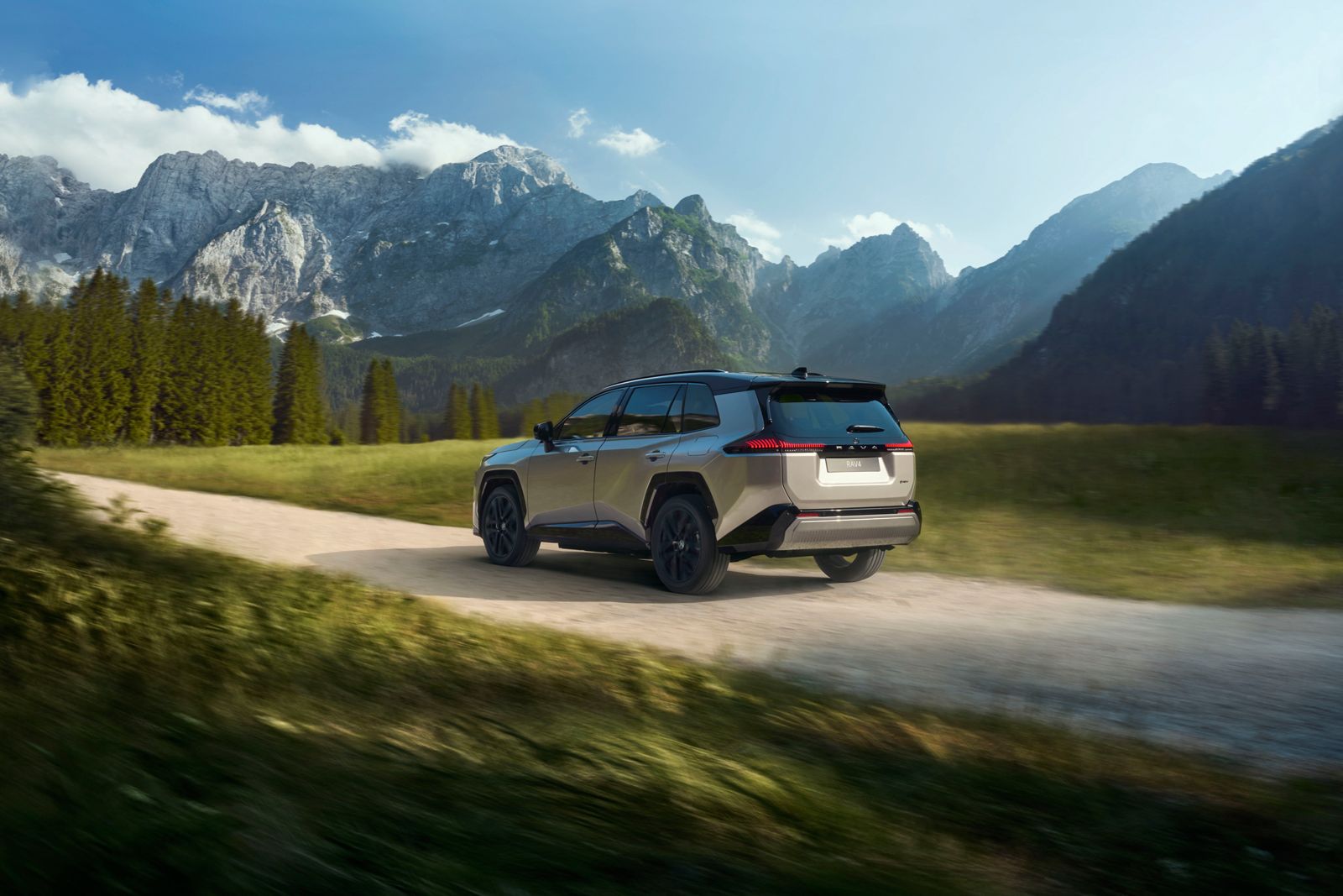 RAV4 Hybrid driving down a dirt road in the mountains