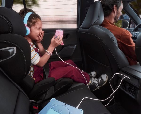 Child using USB charging point in rear of RAV4