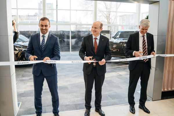 Three men cutting a ribbon infront in a Lexus showroom