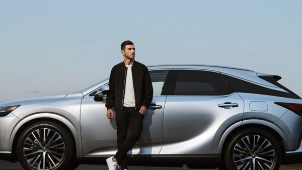 man leaning on a Lexus car