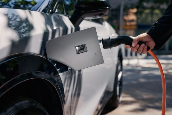 Henkilö laittaa Lexus RZ:n lataukseen