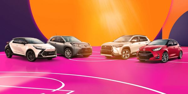 Vier Toyota Fahrzeuge auf dem Innenhof eines modernen Gebäudes mit Glasfront, Bildtext: „LAST MINUTE DEALS, 1,99% EASY FINANZIERUNG“
