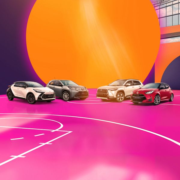 Ein Yaris Hybrid, C-HR und bZ4X stehen nebeneinander auf einem pinken Basketballboden.