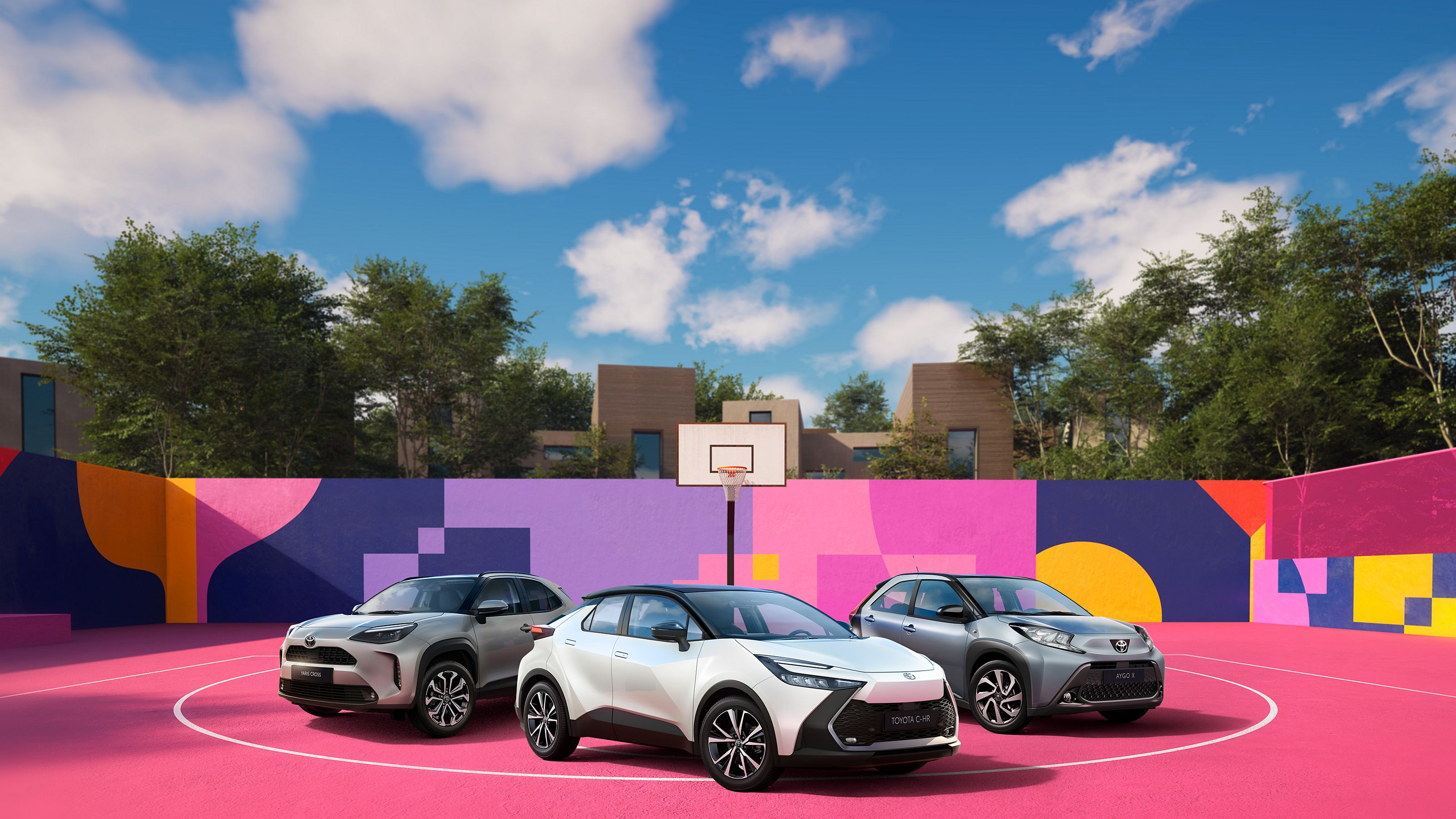 Aygo X, Yaris Cross und C-HR auf einer bunten Backplate, die einen Basketballplatz darstellen. Im Hintergrund einen Basketballkorb. 