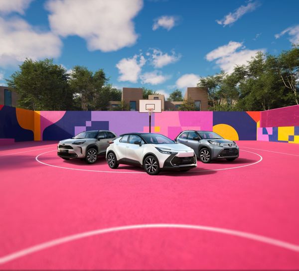 Vier Toyotas stehen auf einem pinken Basketballplatz, der von einer bunt bemalten Wand umgeben ist.