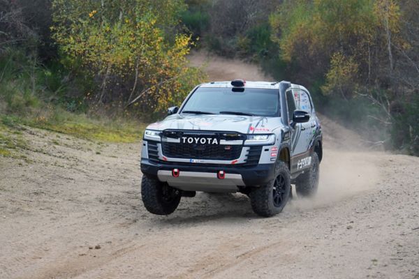 Ein Team Land Cruiser Toyota Karosserie Land Cruiser fährt auf einer staubigen Piste