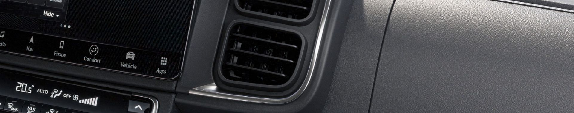 Detail palubní desky s ovládacími prvky klimatizace a infotainment systému.