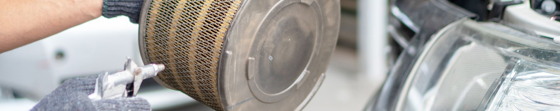 Mechanik čistí vzduchový filtr v autě.