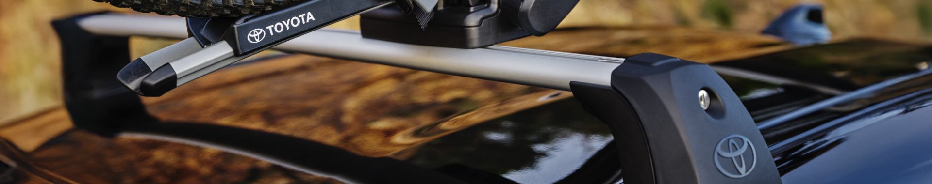 Ruka upevňuje bicykel na nosič Toyoty na zadnej časti vozidla.