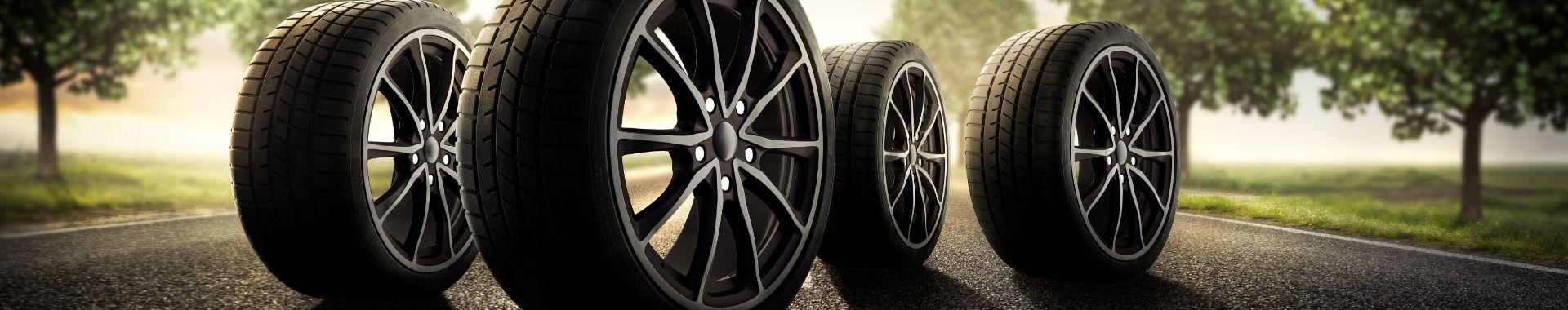 Šedé pozadie s radom automobilových kolies alebo pneumatík vystavených na zemi.